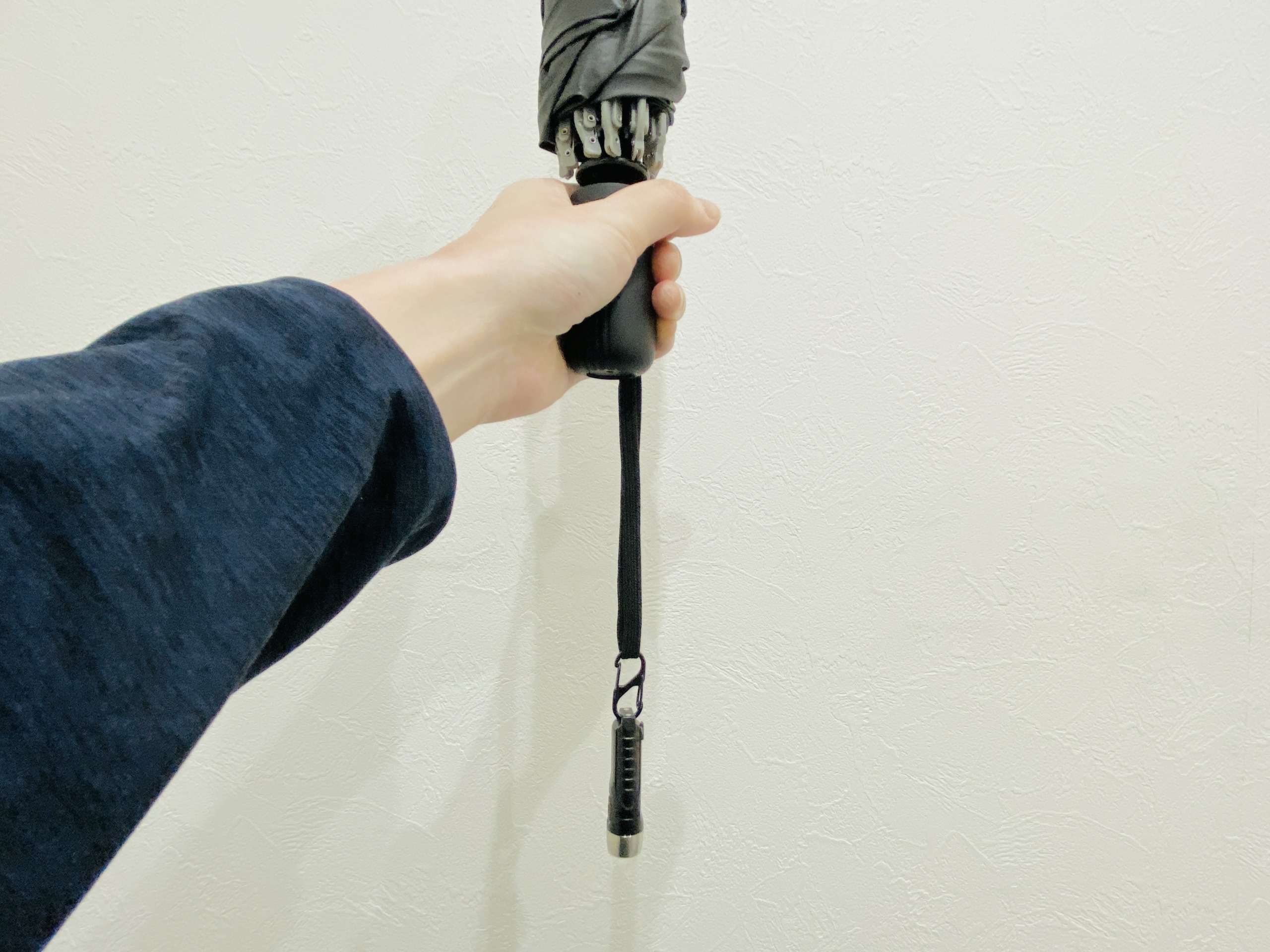傘のストラップにカラビナで取り付けた小型懐中電灯TorchBuddy